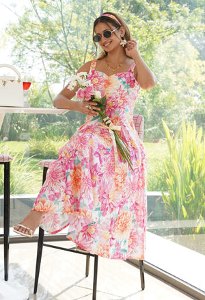 Woman in a colorful floral dress holding flowers indoors.