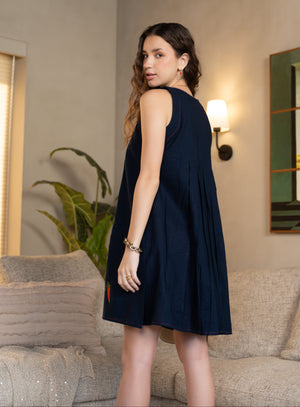 Woman wearing a navy blue dress in a living room setting