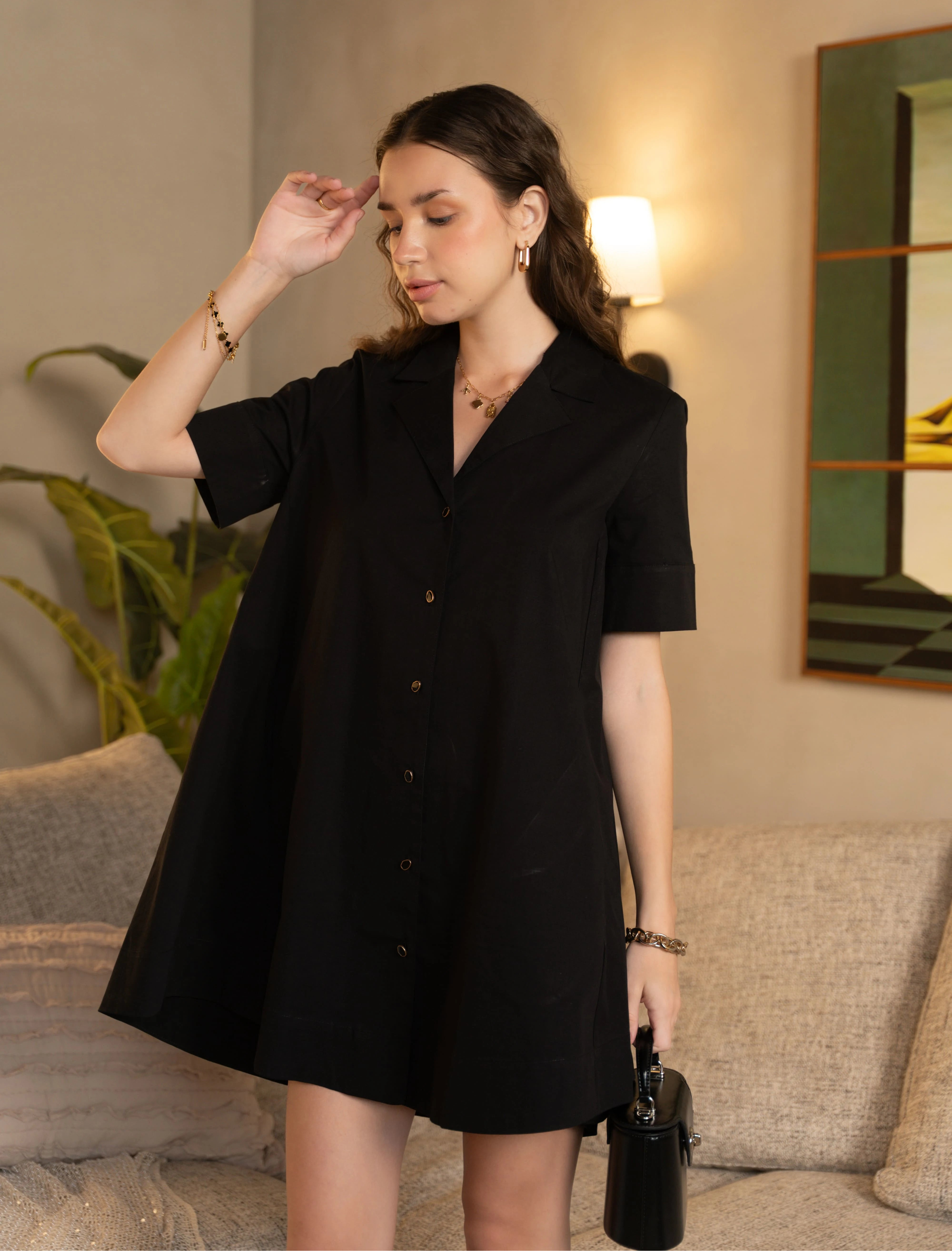 Woman wearing a black dress in a living room setting